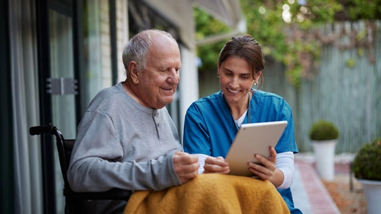 Elderly person in a wheelchair with a healthcare provider, symbolizing stem cell therapy benefits for aging.