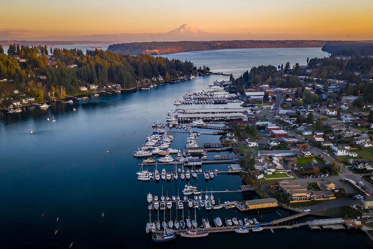 An aerial view of Liberty Lake, Washington, at sunset with a marina full of boats and a vibrant waterfront community, showcasing the beautiful local area for patients seeking advanced stem cell therapy.