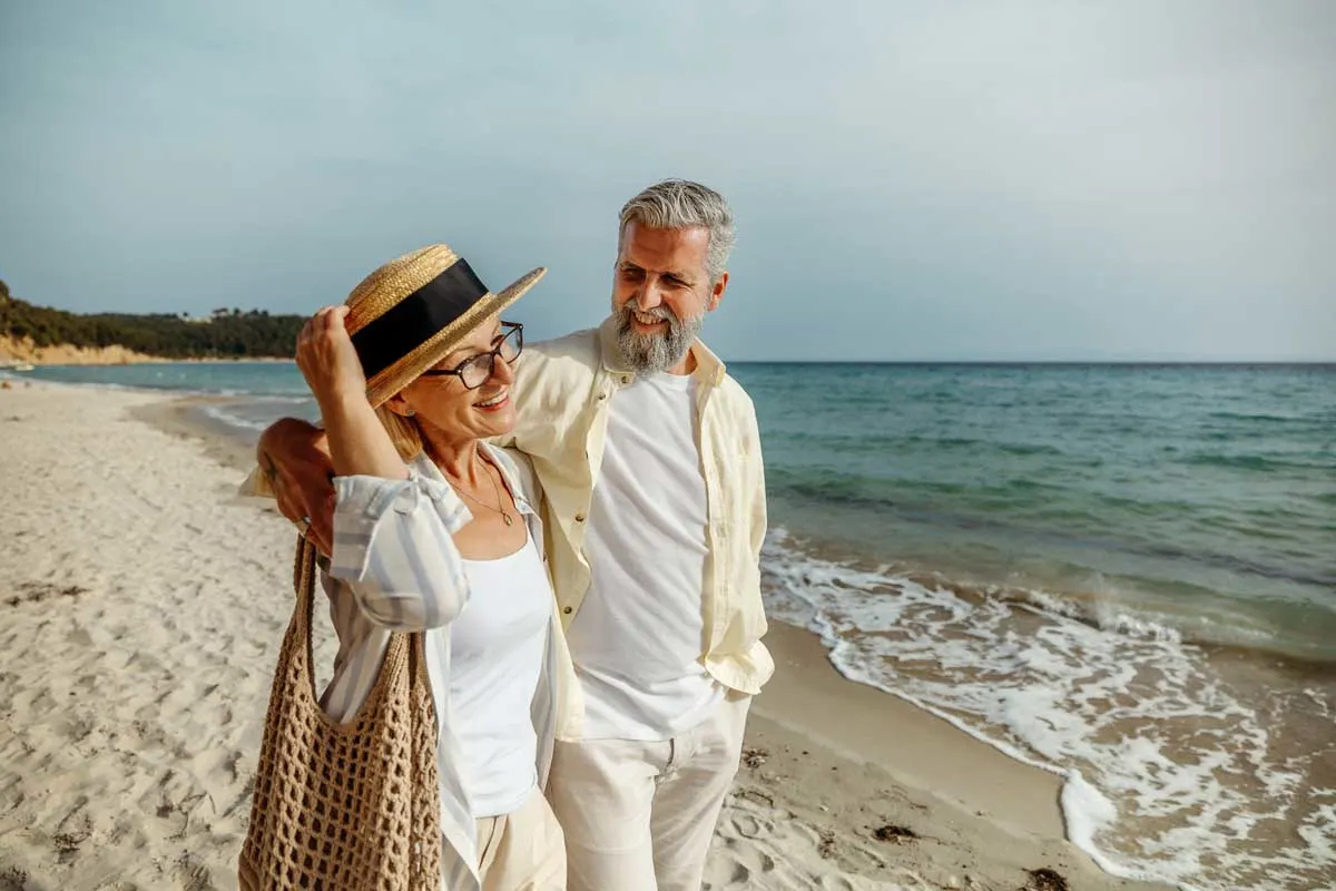 happy-senior-couple-walking-beach-liberty-lake