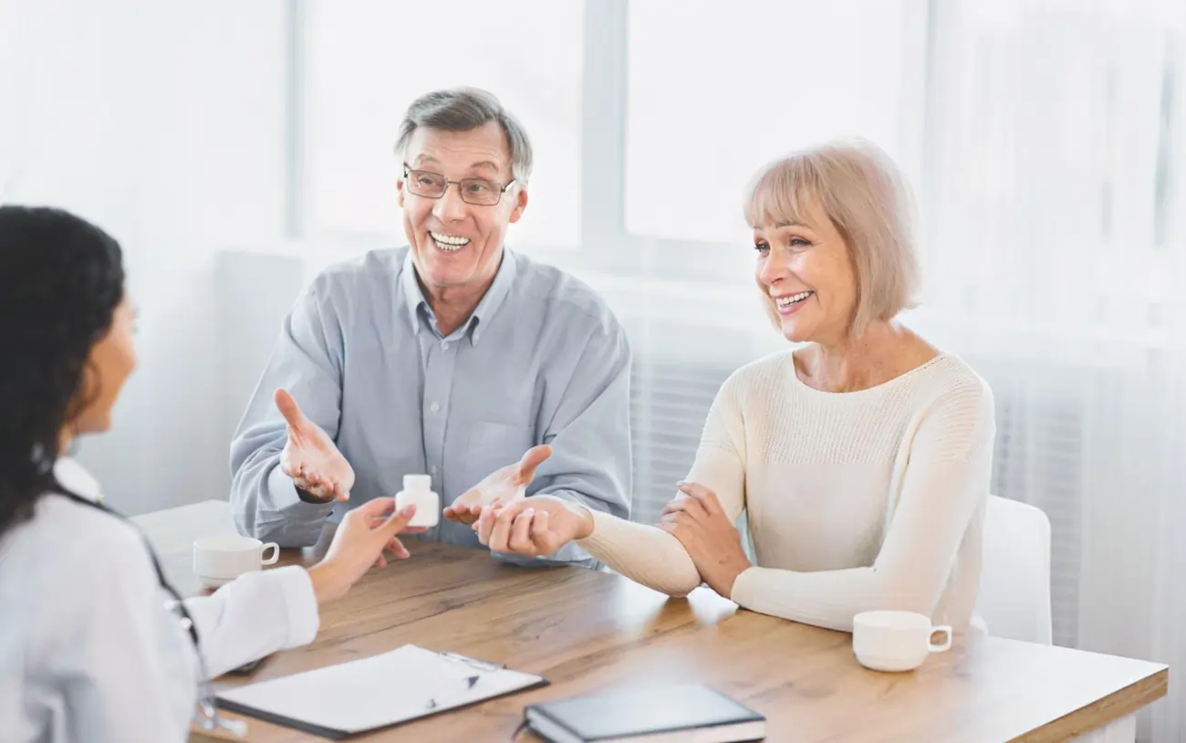 A happy senior couple receives a bottle of medication from a doctor, representing a positive and successful outcome from stem cell therapy or a medical consultation in Battle Creek, Michigan.