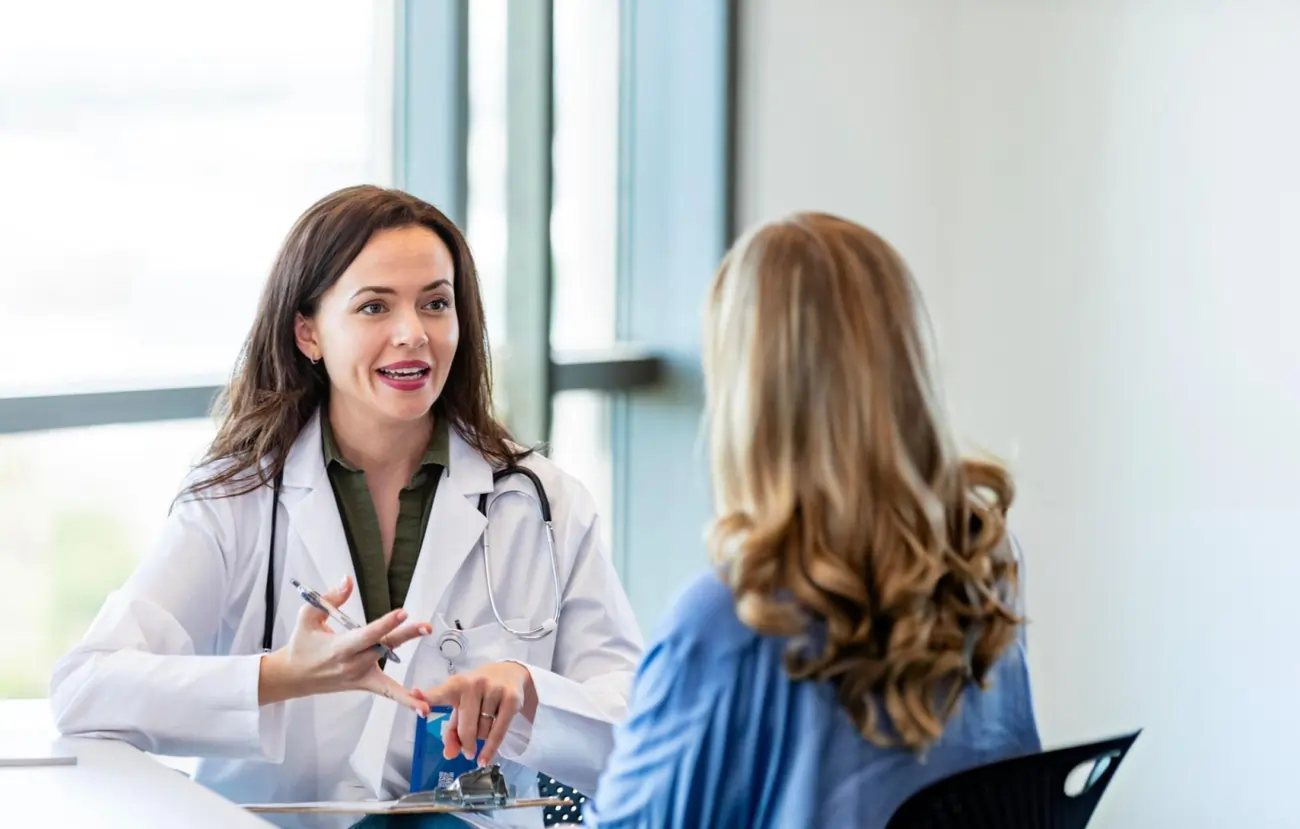 A caring female doctor explains treatment options to a patient during a consultation, demonstrating trust and clear communication about medical procedures like stem cell therapy.
