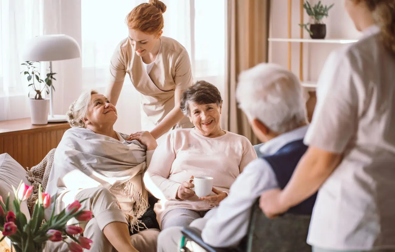 Elderly patients smiling and talking with caregivers, symbolizing the improved quality of life and mobility that can be achieved with regenerative medicine and stem cell therapy.