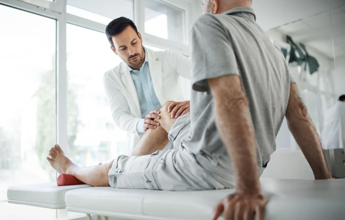 Doctor examining patient’s knee—representing relief from joint discomfort through stem cell therapy in Chesapeake